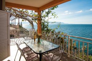 un tavolo e sedie su un balcone con vista sull'oceano di Lemon tree a Podaca