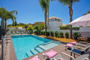 een zwembad met stoelen en palmbomen bij Villa Stefy by Bedzy in Galé