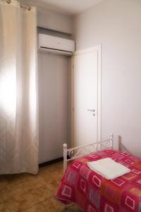 1 dormitorio con 1 cama con manta roja y ventana en B&B Porta Roma en Capua