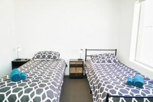 - 2 lits installés l'un à côté de l'autre dans une chambre dans l'établissement Modern style unit 2 Deer Park, à Deer Park