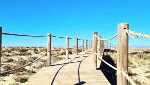 a wooden boardwalk in the sand in the desert at Zenit charm Olhao relax cubist House in Olhão