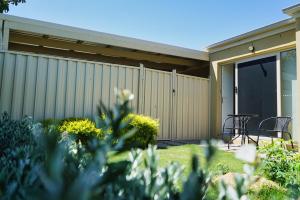 a house with a fence and a table and chairs at Modern style unit 2 Deer Park in Deer Park