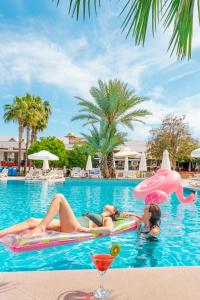 Dos mujeres tumbadas en una balsa en la piscina de un complejo en Barut B Suites, en Side