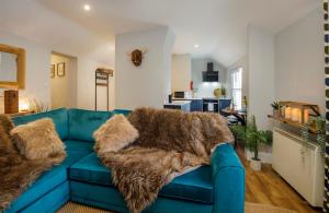 eine blaue Couch mit einem pelzigen Teppich im Wohnzimmer in der Unterkunft The Holgate Snug in York