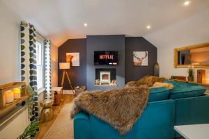 ein Wohnzimmer mit einem blauen Sofa und einem TV in der Unterkunft The Holgate Snug in York