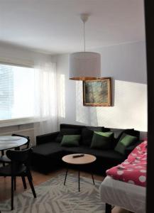 sala de estar con sofá negro y mesa en Studio middle of town centre., en Tornio
