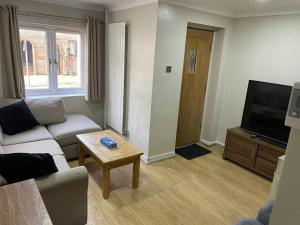 a living room with a couch and a tv and a table at Rainbow Quays in London