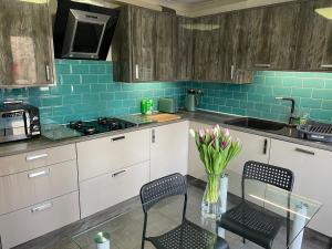 a kitchen with two chairs and a table with a vase of flowers at Rainbow Quays in London