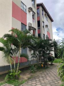 a building with palm trees in front of it at Talats_HomeCharm in São Luís