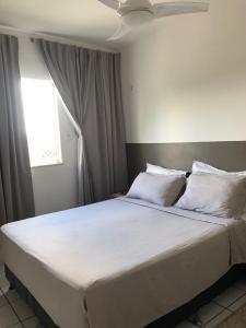 1 dormitorio con 1 cama grande con sábanas y almohadas blancas en Talats_HomeCharm en São Luís