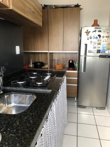 a kitchen with a stainless steel refrigerator and a sink at Talats_HomeCharm in São Luís