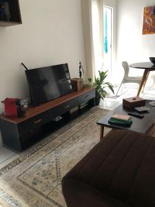 a living room with a flat screen tv on a entertainment center at Talats_HomeCharm in São Luís