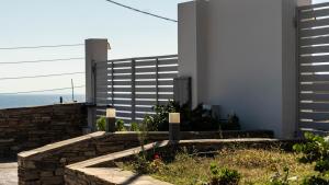 a house with a stone wall and a building at Antigoni Villas in Gavrio