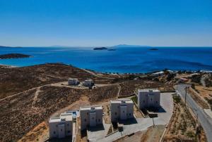 an aerial view of the ocean and buildings on a hill at Antigoni Villas in Gavrio