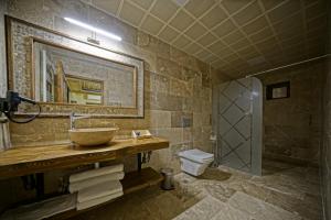 a bathroom with a sink and a toilet and a mirror at Zultanite Cappadocia Hotel in Nevşehir