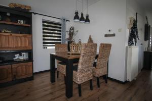 - une salle à manger avec une table et des chaises en osier dans l'établissement Sfeervol chalet op de Veluwe, à Putten