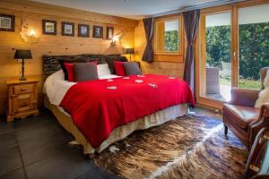 sypialnia z dużym łóżkiem i czerwonym kocem w obiekcie Lodge le Chevreuil - OVO Network w mieście Le Grand-Bornand