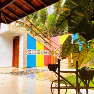 ein Haus mit farbenfroher Wand mit Fahrrad davor in der Unterkunft Princesinha do Sul in Ilhéus