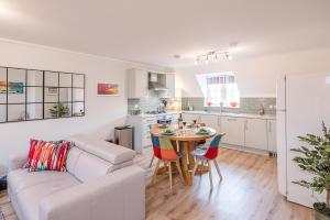 a living room with a couch and a table with chairs at 10 Acorn Close Aldringham in Leiston