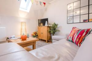 a living room with a white couch and a table at 10 Acorn Close Aldringham in Leiston