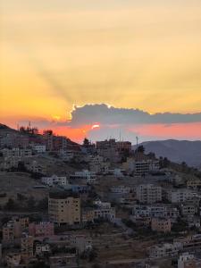 a city skyline with a sunset in the background at Rocky Mountain Hotel in Wadi Musa