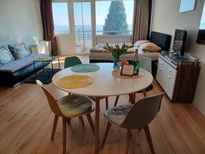 a living room with a table and chairs and a couch at Appartment Panoramablick in Oberteuringen