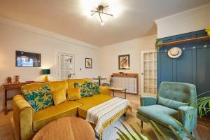 a living room with a yellow couch and a chair at The Jungle Nook; Romantic Haven in Berwick-Upon-Tweed