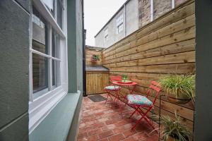 a patio with three chairs and a table and a fence at The Jungle Nook; Romantic Haven in Berwick-Upon-Tweed