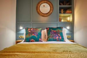 a bedroom with a bed with two pillows and a mirror at The Jungle Nook; Romantic Haven in Berwick-Upon-Tweed
