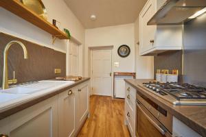 uma cozinha com um lavatório e um fogão forno superior em The Jungle Nook; Romantic Haven em Berwick-Upon-Tweed