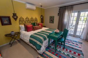 sypialnia z dużym łóżkiem i zielonym stołem w obiekcie Baruch Guesthouse on Lovell w mieście Stellenbosch