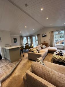 a large living room with couches and a table at Lowena Lodge in Troutbeck
