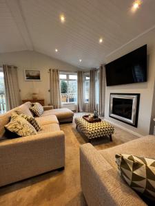 a living room with two couches and a fireplace at Lowena Lodge in Troutbeck