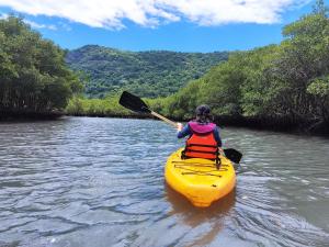 een vrouw peddelt een kajak op een rivier bij Mangue House lll in Rio de Janeiro