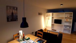 a living room with a dining room table and a kitchen at Ferienwohnung Meiringen in Meiringen