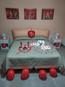 Schlafzimmer mit einem Bett mit roten Herzen in der Unterkunft B&B Petra Hercules in Torre Annunziata