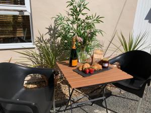 una mesa con una botella de vino y comida. en Sandsifter at 4 Trencrom Court, Carbis Bay,St Ives, Cornwall en Carbis Bay