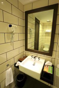 y baño con lavabo blanco y espejo. en Namin Dago Hotel, en Bandung