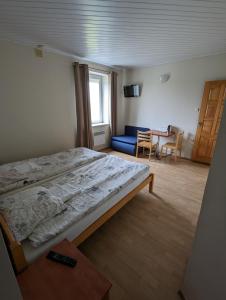 a bedroom with a large bed and a blue couch at Trevena Endriejavas 