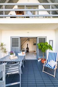 a patio with a table and chairs on a house at Madarász Deluxe Vendégház in Balatonalmádi