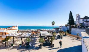 een groep tafels en paraplu's in een stadsstraat bij Pousada Alfama in Lissabon