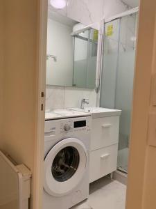 - un lave-linge dans la salle de bains pourvue d'un lavabo dans l'établissement Studio en hypercentre refait à neuf avec une belle terrasse!, à Cabourg