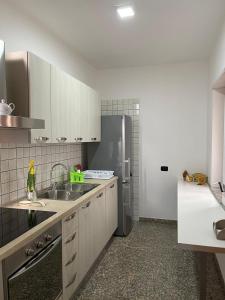 una cucina con mobili bianchi e un frigorifero in acciaio inossidabile di Marval a Monopoli