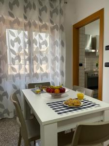 un tavolo bianco con un cesto di frutta sopra di Marval a Monopoli Altre 14 foto