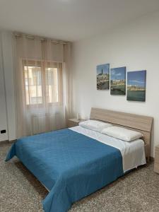 una camera da letto con un letto grande con una coperta blu di Marval a Monopoli