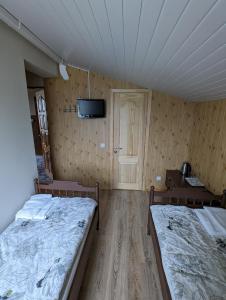 a room with two beds and a tv on the wall at Trevena Endriejavas 