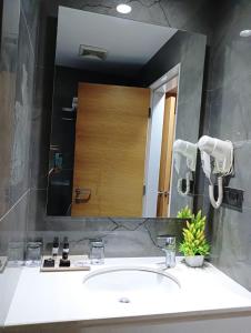 ein Badezimmer mit einem Waschbecken und einem großen Spiegel in der Unterkunft Hotel Suba Elite Vadodara in Vadodara