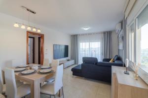 ein Wohnzimmer mit einem Tisch und einem blauen Sofa in der Unterkunft Club Villamar - Santelmo in Lloret de Mar