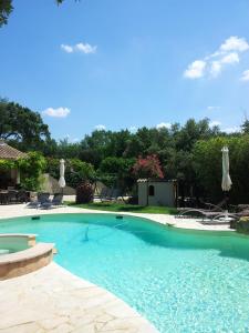 ein großer Pool mit blauem Wasser im Hof in der Unterkunft Santolines en Provence in Piolenc