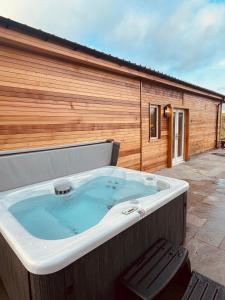 a large hot tub in front of a building at East Learmouth Lakeside Lodges - Larch Lodge in Cornhill-on-tweed